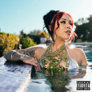 A woman with red hair leans over the edge of a swimming pool, wearing a silver bikini top and a ornate gold necklace. The image has a Parental Advisory label in the bottom right corner.